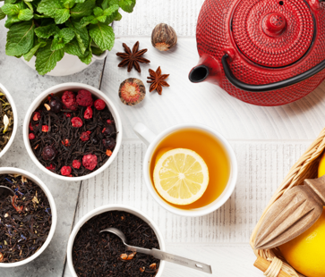 A white table with coffee, tea, lemon, mint.